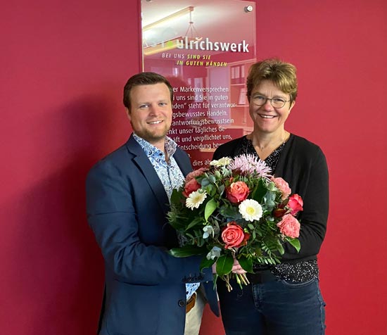 Blumen zum Jubiläum: Bereichsleiter Matthias Bronner gratuliert Monika Gasteiger zum 25-jährigen Betriebsjubiläum.